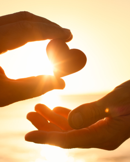 Hand sharing a small heart with another hand