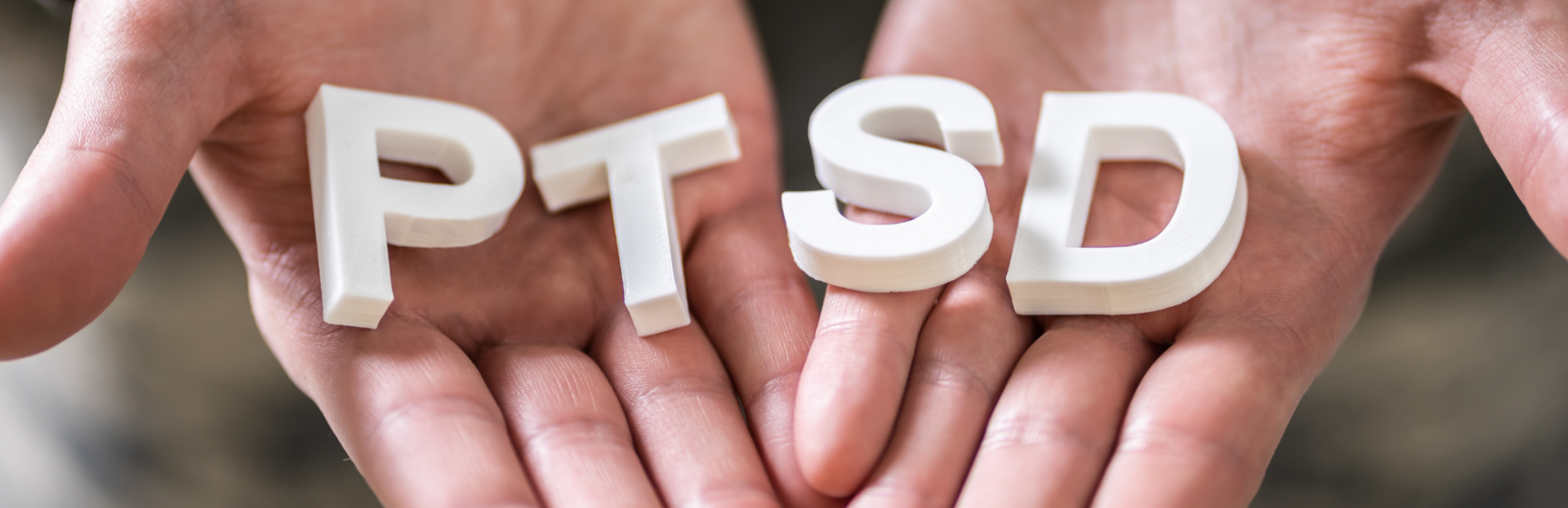 Hands holding the letters PTSD