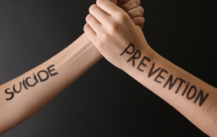 Hands Linked with Suicide Prevention Words on Arms